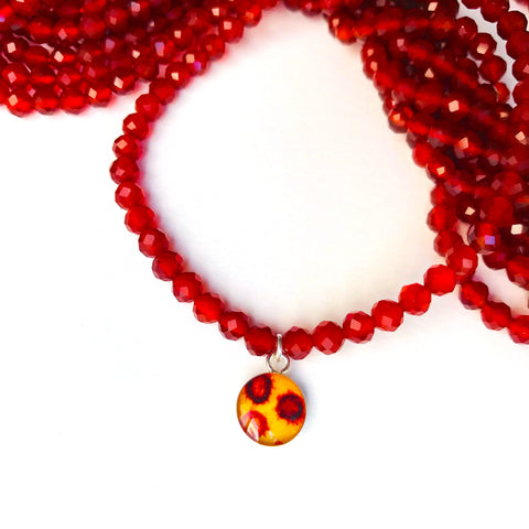 close up of covid 19 image pendant and red carnelian bead stretch bracelet 