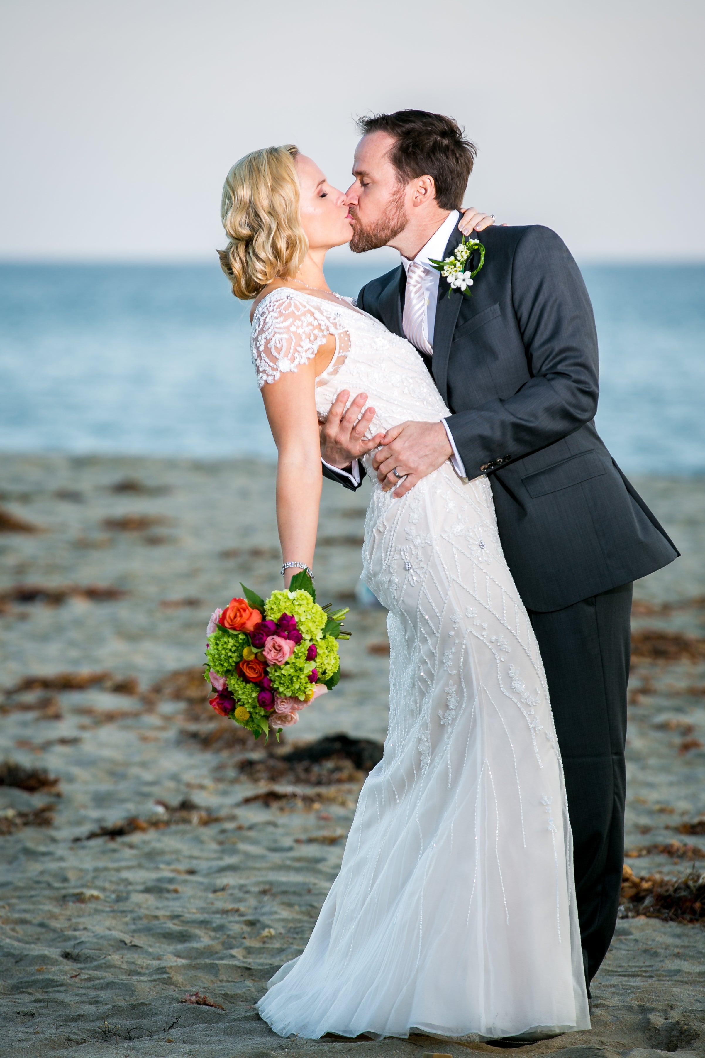 Nikki and Robby kissing on the beach on their wedding day