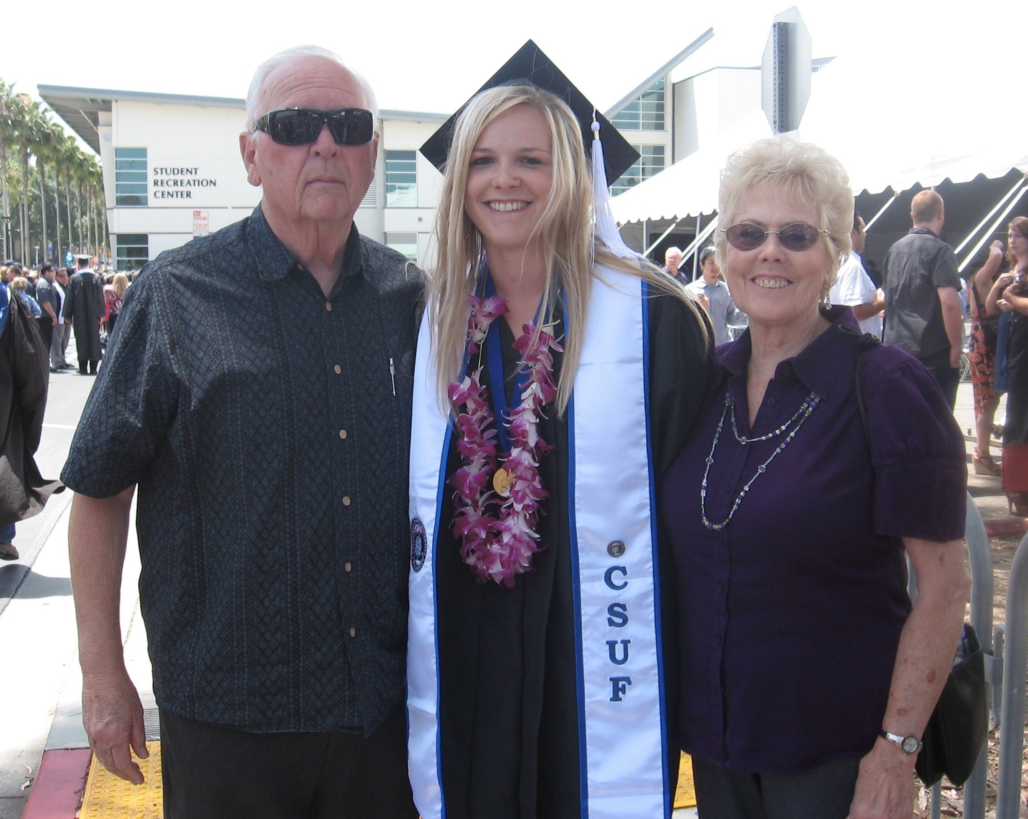 nikki on graduation day from CSUF with her grandma and grandpa