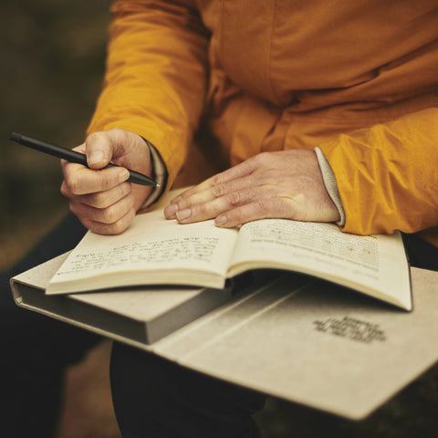 man writing in a journal