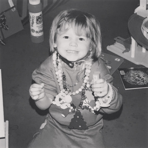 Nikki as a baby with lots of necklaces on