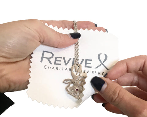 Cleaning jewelry with a custom Revive Jewelry polishing cloth