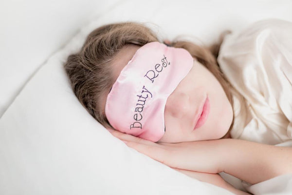 woman in sleep mask sleeping in bed