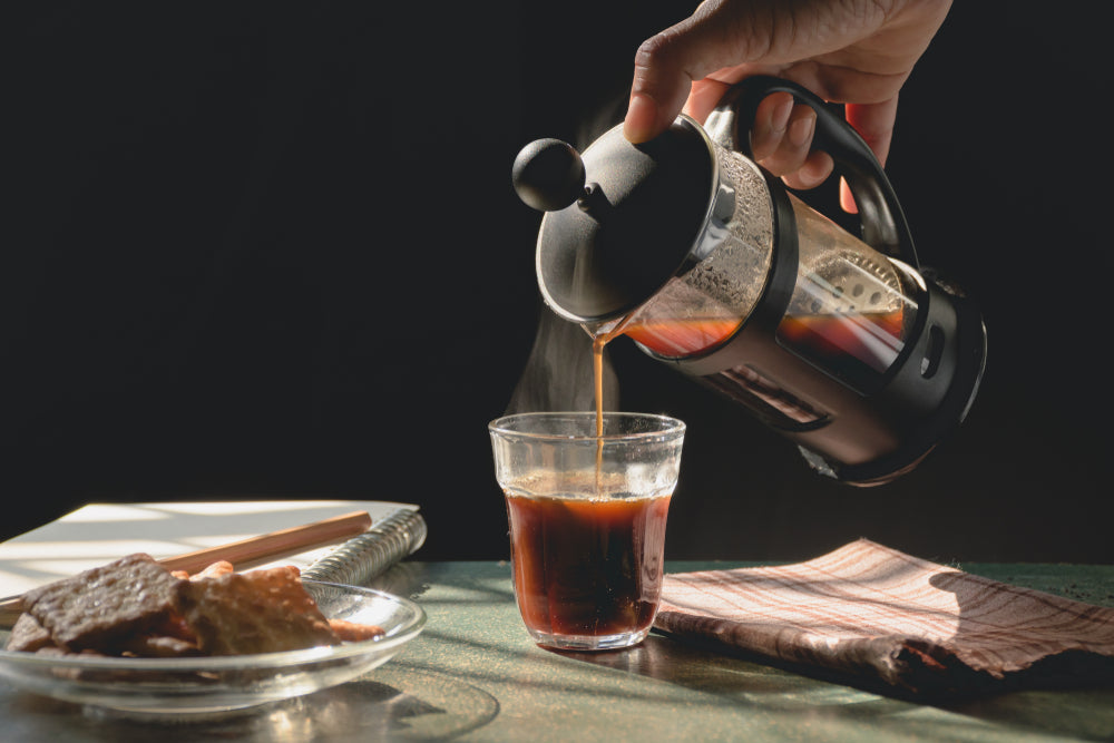 Aromatic coffees with hot smoke are poured into couple cup from French press coffee maker