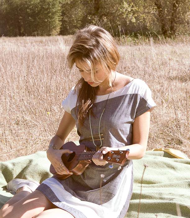 A betsy and iya model playing ukelele in the sun.