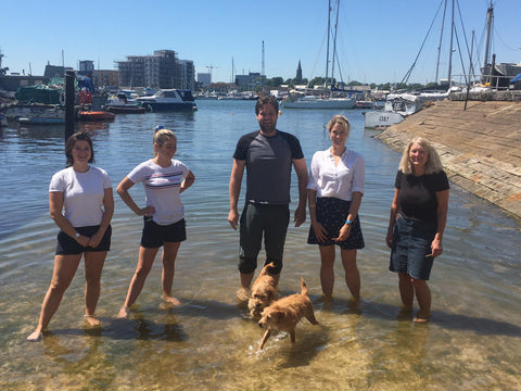 Die TeamO-Crew kühlt sich an einem sonnigen Sommertag die Füße im Fluss Itchen ab und macht eine Pause vom Anfertigen von Schwimmwesten, um gemeinsam Eis zu essen