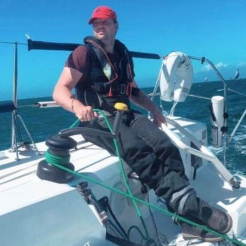 Oscar Mead, Gründer von TeamO Marine, segelt mit einer seiner eigenen TeamO Offshore-Rettungswesten an einem sonnigen Tag im Ärmelkanal