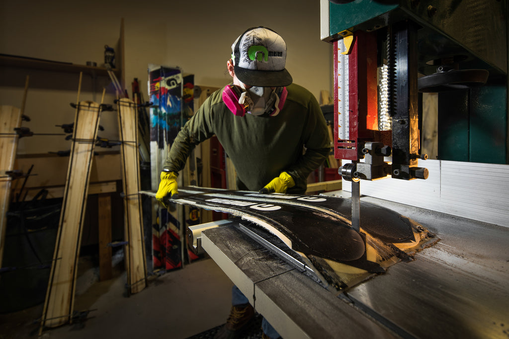 A man wears a respirator mask and gloves as he builds custom skis at Meier Skis in Denver, CO