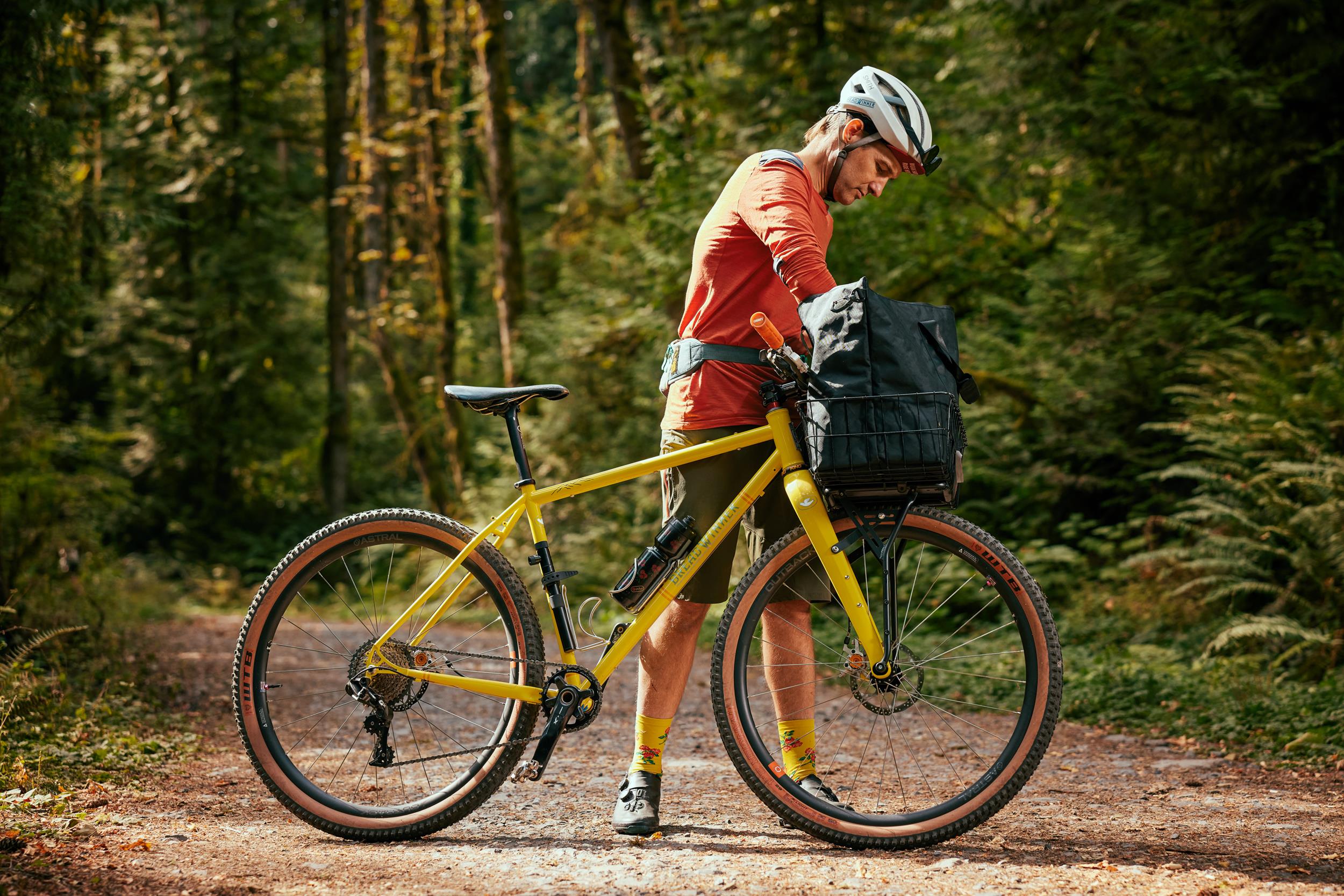 Image of a rider reaching into a PDW Loot Bag mounted on the front of their bike.