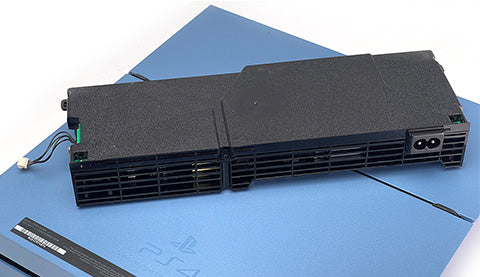 A power supply on top of a PS4 
