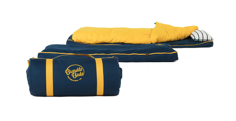 An unrolled Bundle Beds travel bed with a cosy duvet and pillow