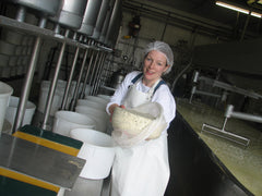 Marieke Penterman with a wheel of freshly made gouda cheese