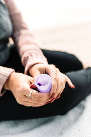 Femme tenant une tasse de simplicité violette