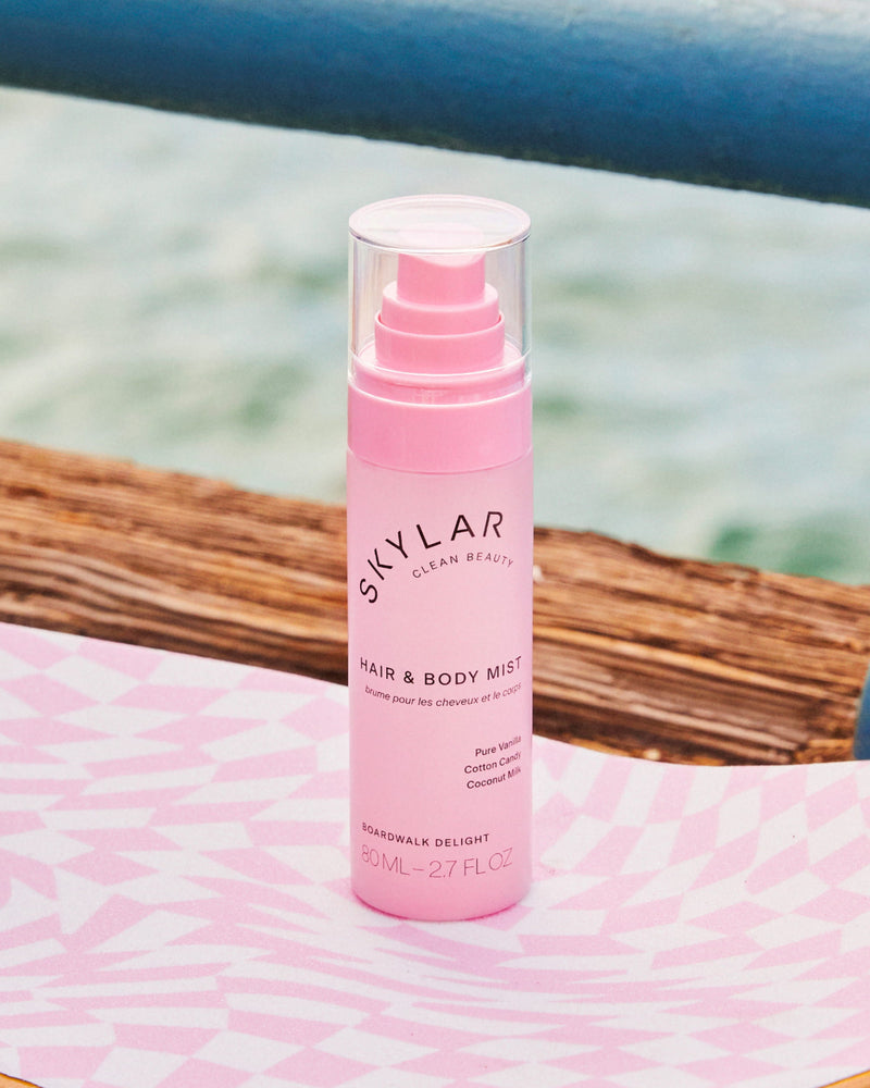 Skylar Boardwalk Delight Hair & Body Mist in a travel-size spray bottle by the ocean.