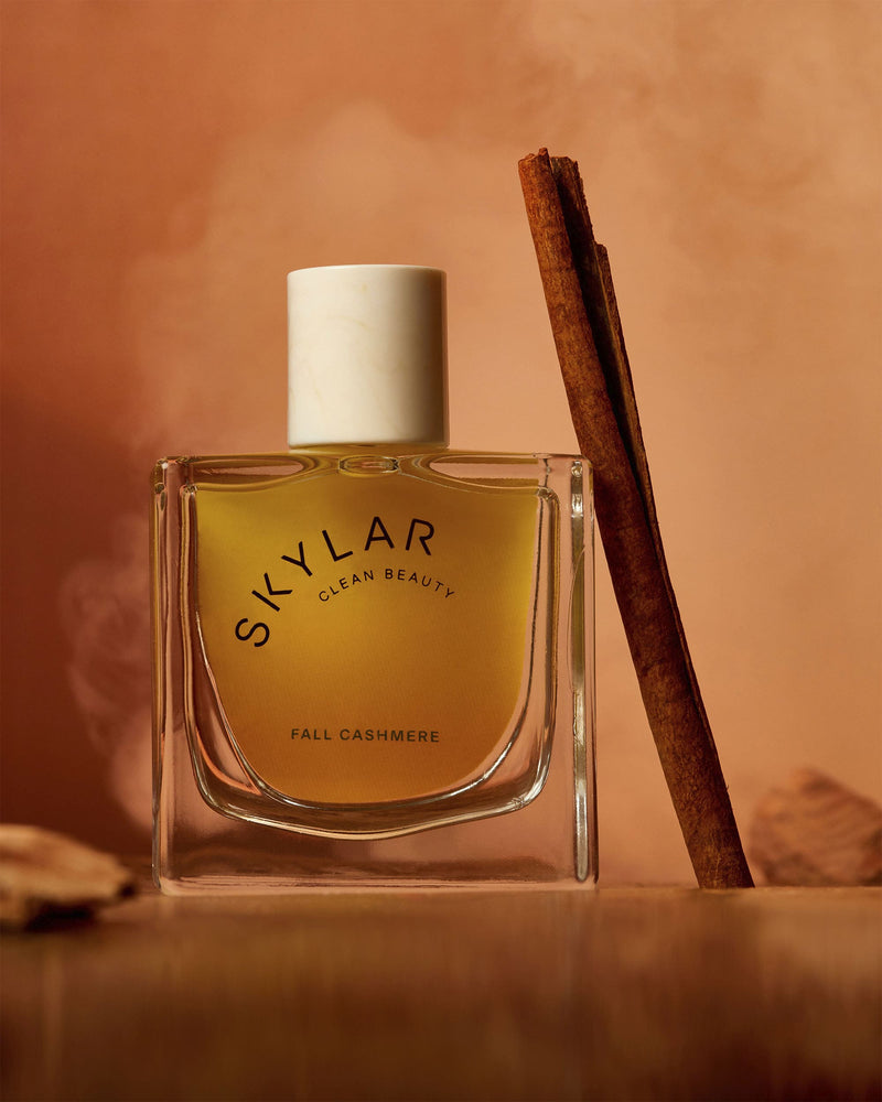 Skylar Fall Cashmere: Full-size bottle with a spicy vanilla scent next to a cinnamon stick.