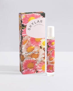 Super Bloom fragrance: Travel-size bottle with a floral scent displayed next packaging box.