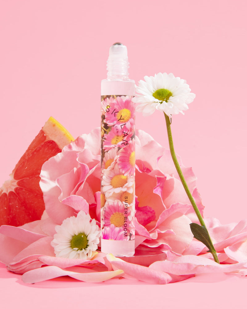 Super Bloom fragrance: Travel-size bottle with a floral scent surrounded by grapefruit and flowers.