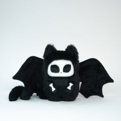 Bat kitty plushie with a skelly face and hands