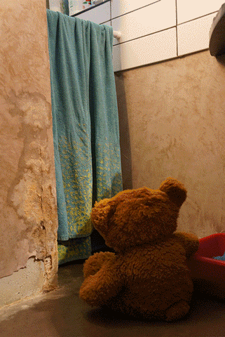 animated gif of a teddy bear going to wash himself in a washing machine