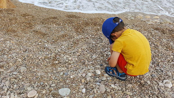 A little kids on a rock beach