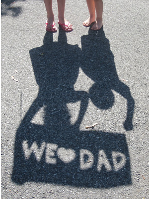 Shadow of two little girls holding a We love dad sign