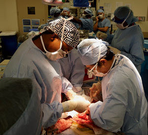 Dr. Tomoaki Kato (R)  Dr. Anthony Watkins (L) operate on a cancerous tumor - surgicalcaps.com