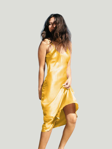 Model is wearing yellow Ocean Prairie Sundrop Silk Slip Dress