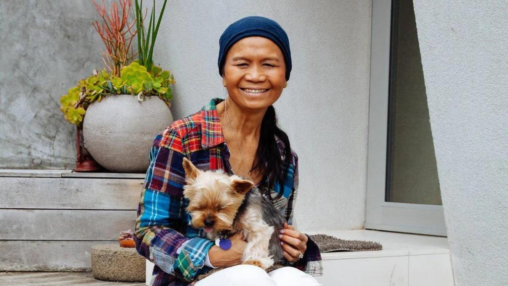 Fashion designer and creator Chan Luu sits on the porch with her dog