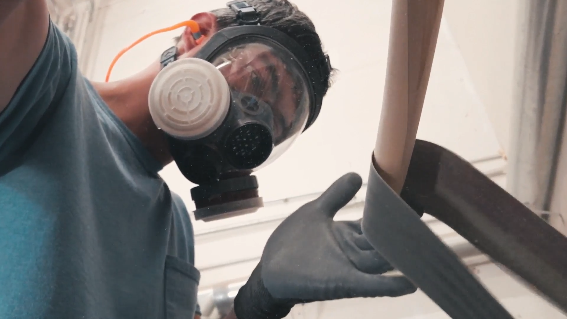 Ambrose Sleister III sanding a KIALOA Hybrid Outrigger paddle shaft.