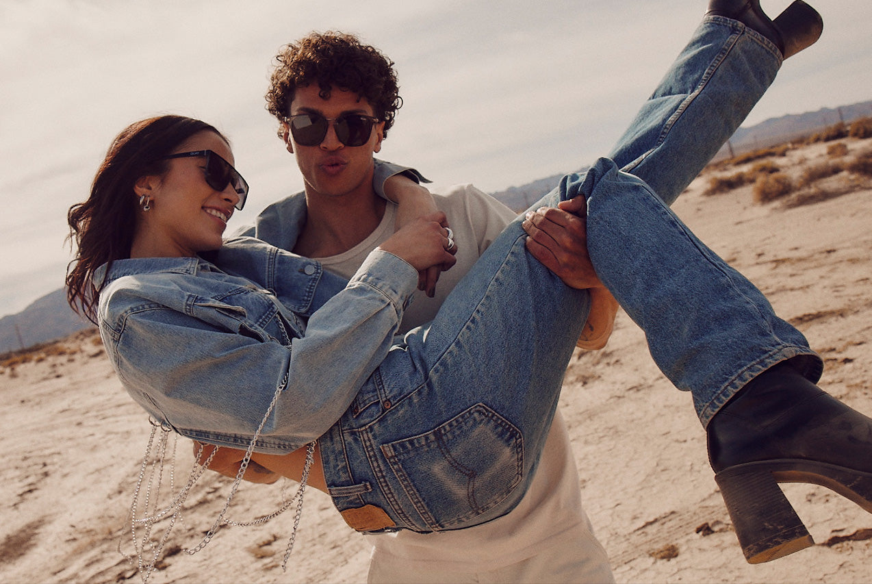 Model playfully carrying a women through the desert