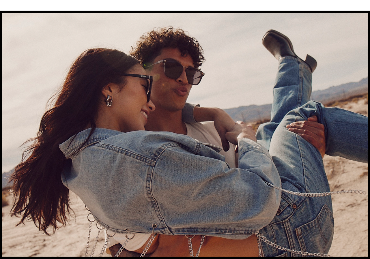 Model playfully carrying a women through the desert