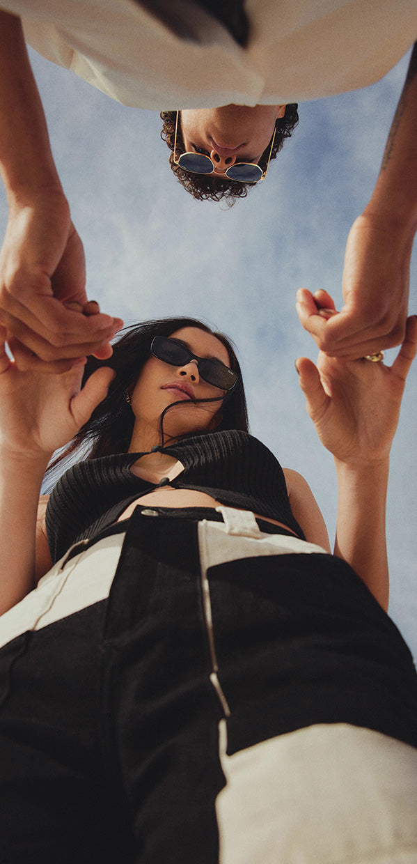 Upward angle shot of two models holding hands