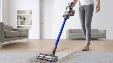 Women using dyson vacuum on carpet in living room  