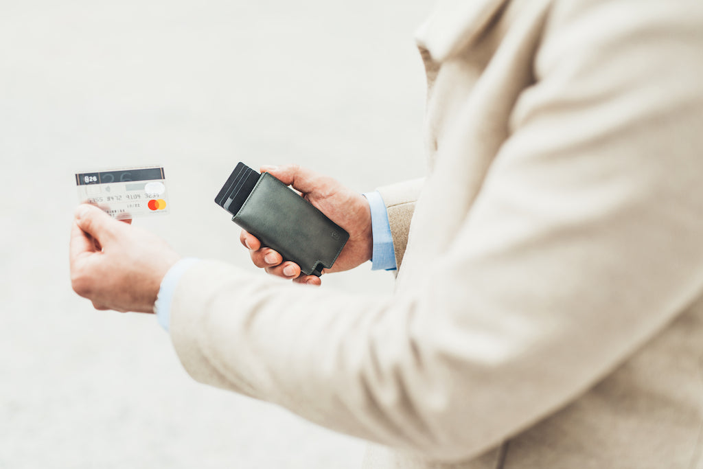 Man removing card from a leather trigger wallet. 