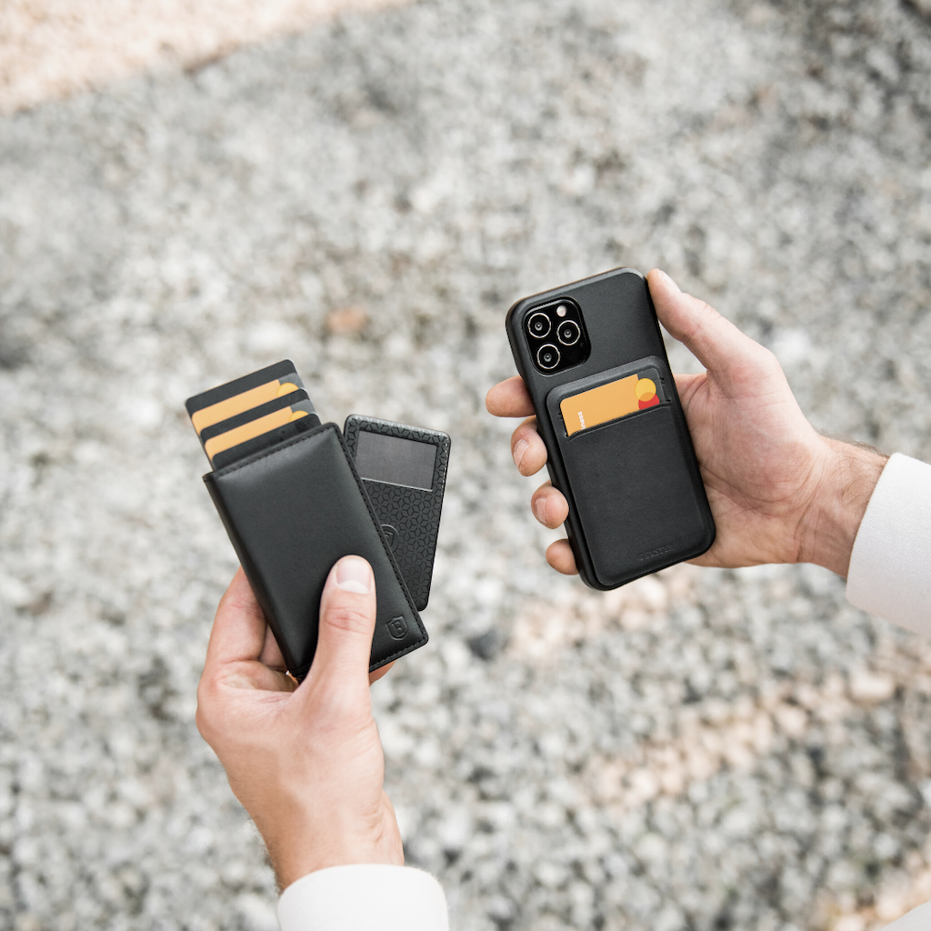 man's hands holding leather wallet and iphone