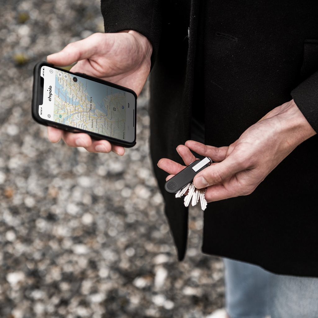 Person’s hands holding Key Holder with Key Tracker while tracking location on the Chipolo app
 