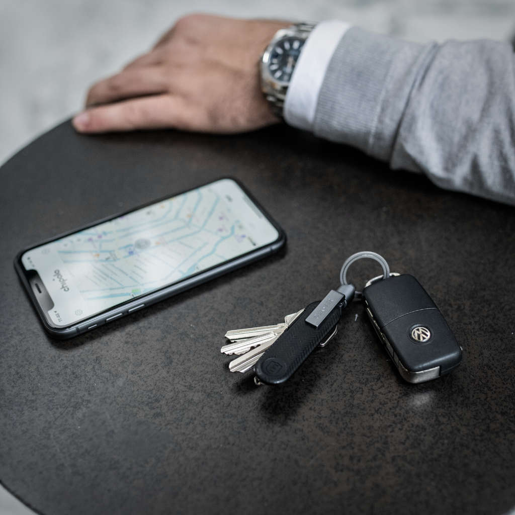 Person’s hand with Key Holder and Key Tracker on car keys, tracking location on the Chipolo app
