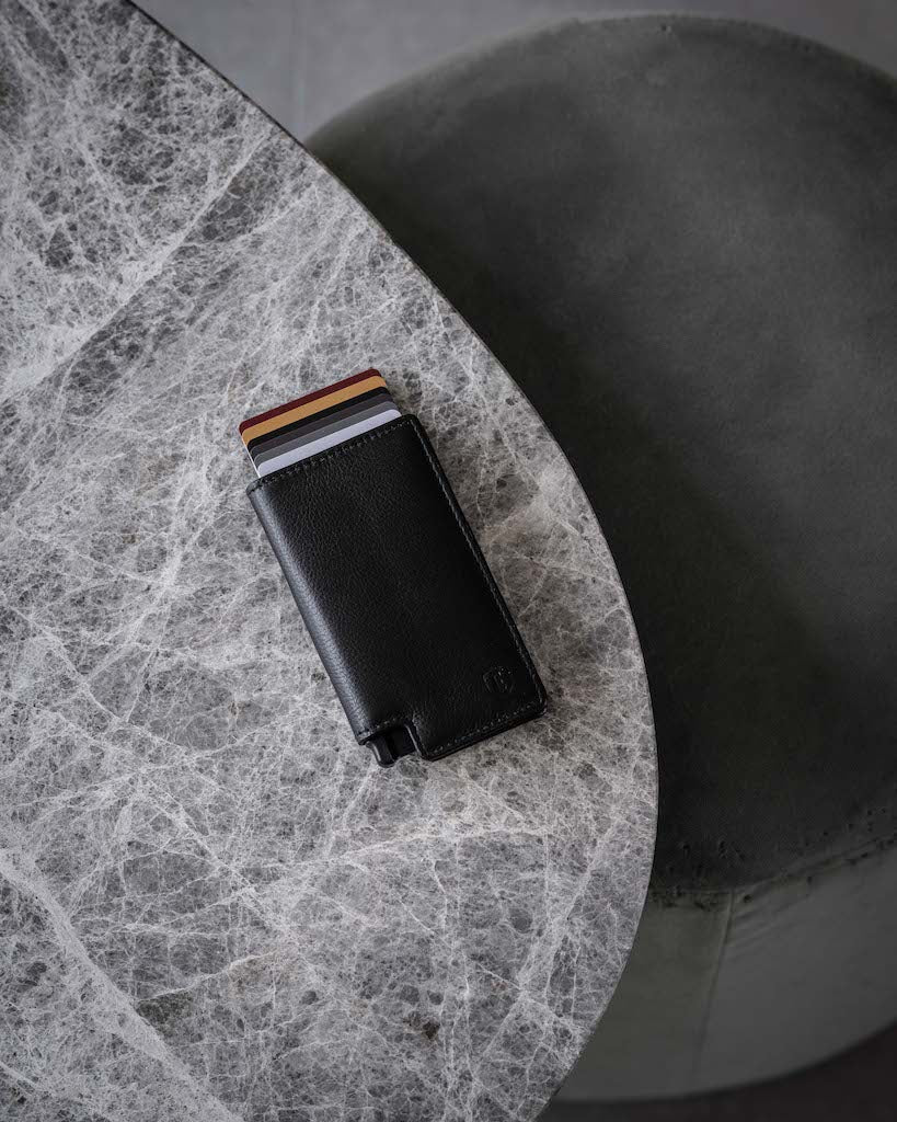 black leather wallet lying on marble table