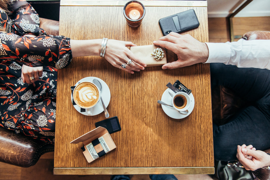 two people exchanging small gift at cafe