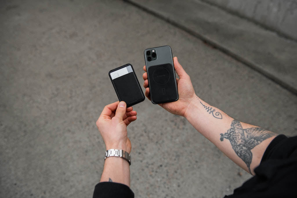 Man holding a magsafe carholder in his left hand and a phone with magsafe sticker in his right hand.