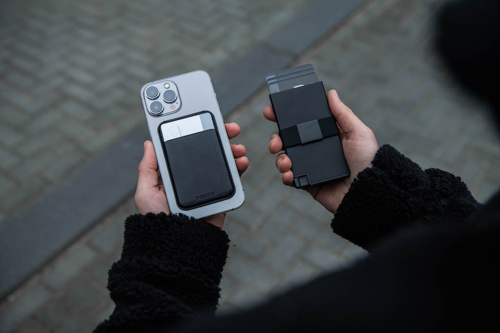 Person's hands holding iPhone with MagSafe cardholder on the back