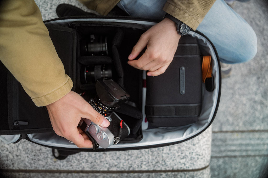 man packing camera gear into a backpack