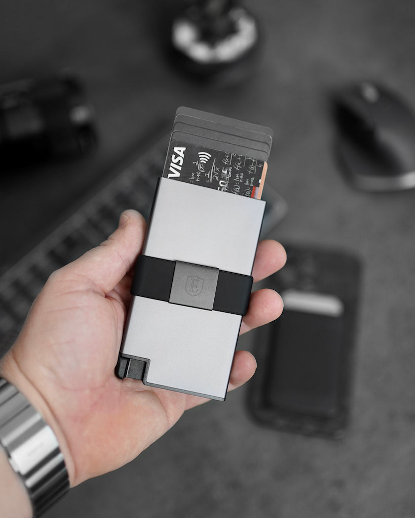 a man's hand holding an aluminum cardholder wallet with pop up cards