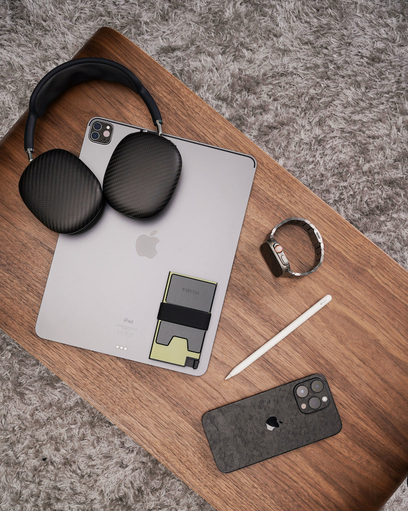 wallet, headphones, watch, pen, tablet, and phone on a desk