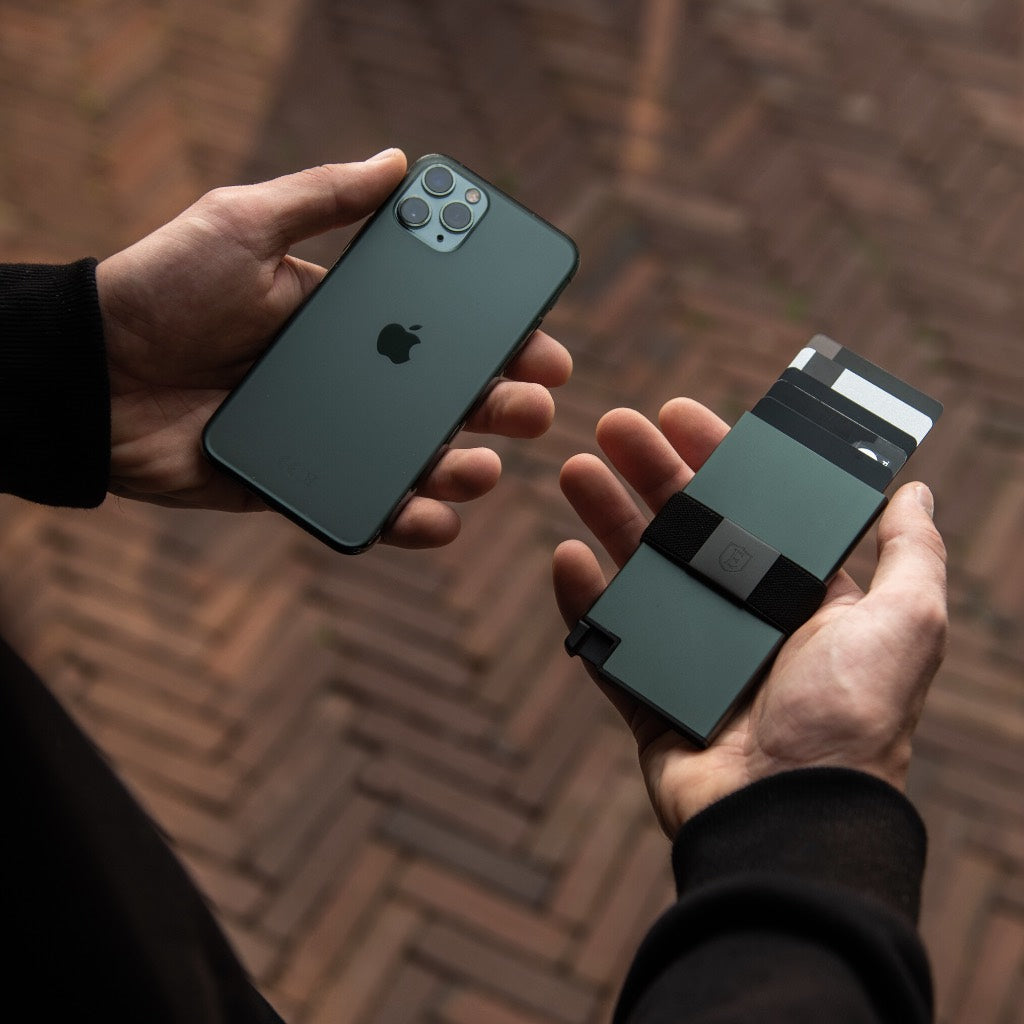 Mans hands holding a green Ekster Aluminum Cardholder and matching iPhone.