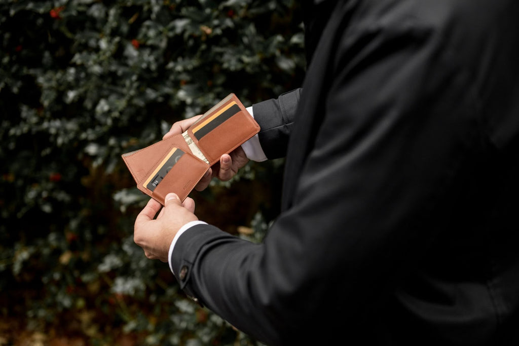 man removing a card holder from leather bi-fold wallet