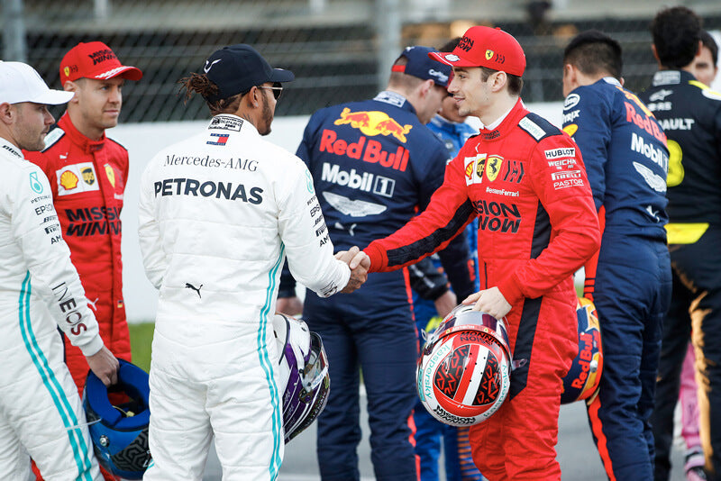 F1 drivers Hamilton and LeClerc shake hands.
