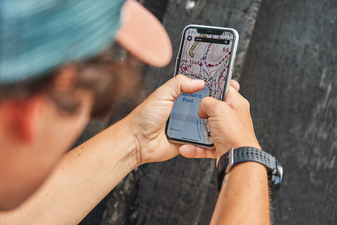 Hands holding phone with OS Maps app visible on screen