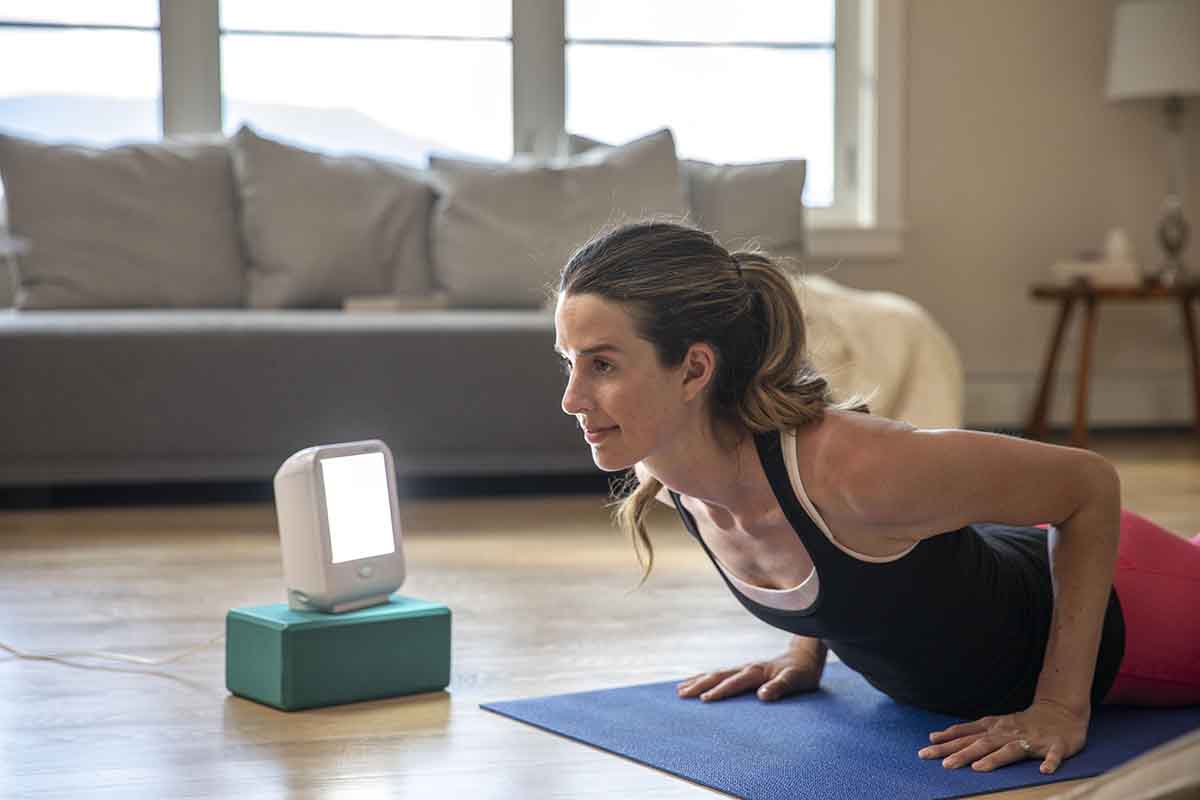 Woman doing yoga pose next to happylight compact