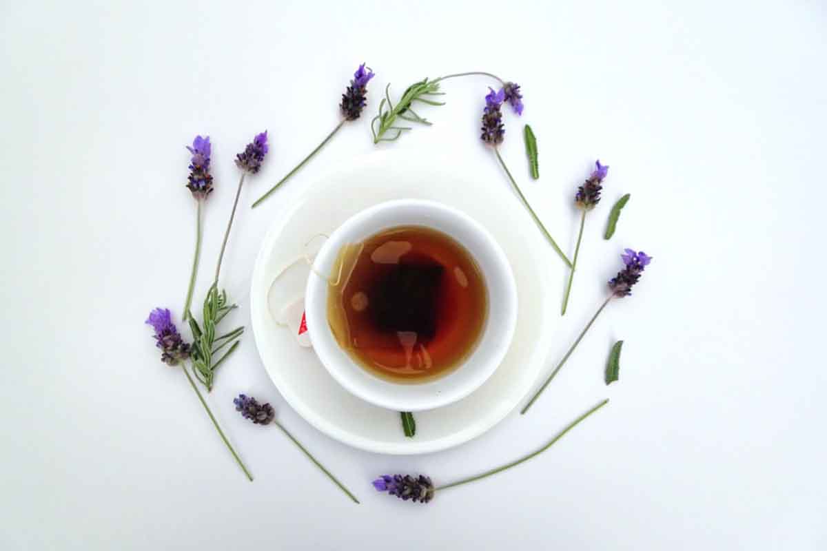 Tea in a white cup surrounded by flowers